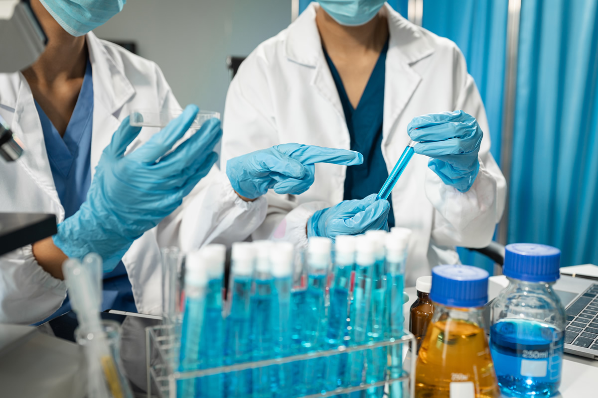 Lab techs holding chemicals